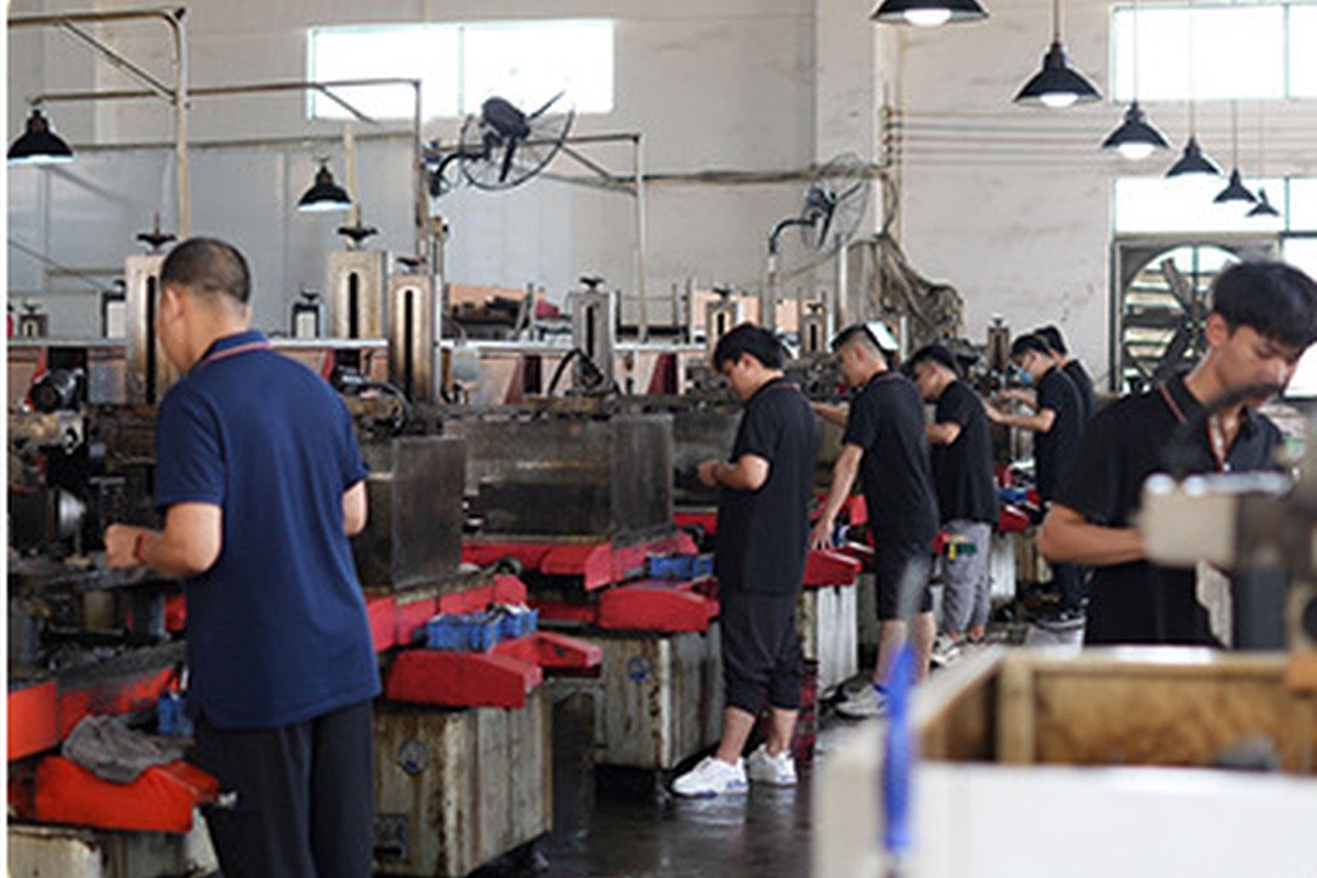 Metalworking production team operating workshop equipment
